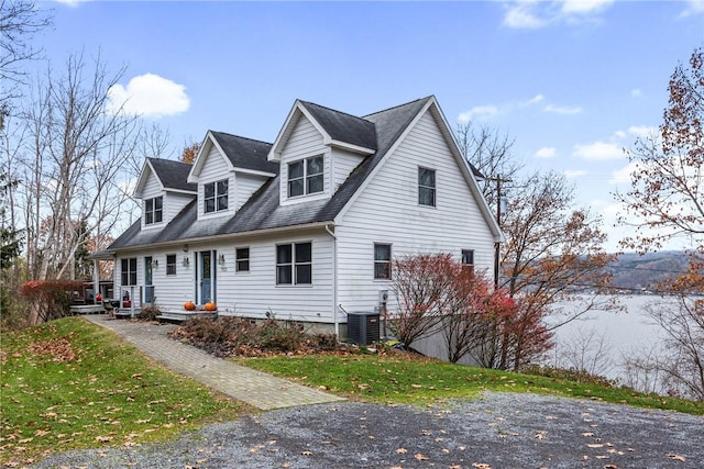 cape cod house with central air condition unit and a front lawn