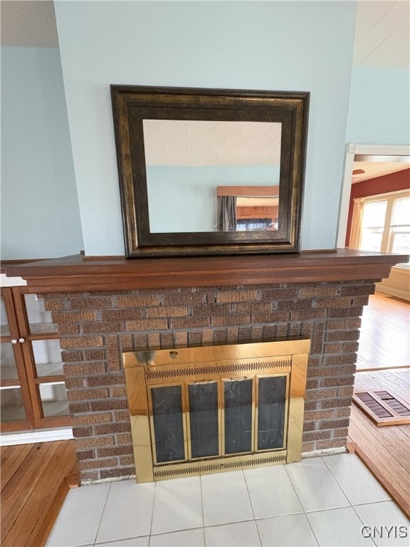 interior details with tile patterned floors and a fireplace