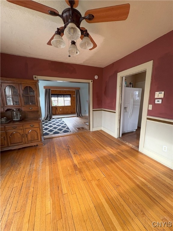 interior space with ceiling fan, light hardwood / wood-style flooring, and a textured ceiling