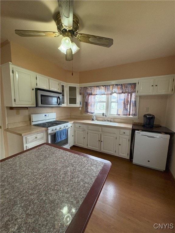 kitchen with white appliances, sink, ceiling fan, light wood-type flooring, and white cabinetry