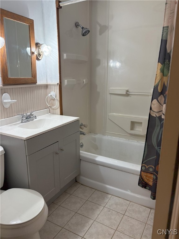 full bathroom featuring shower / bath combo with shower curtain, tile patterned flooring, vanity, and toilet