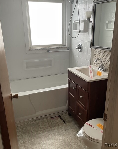 full bathroom with washtub / shower combination, decorative backsplash, vanity, and toilet