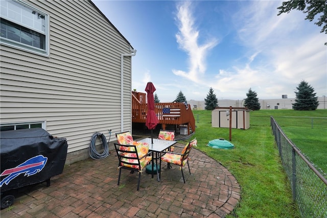 view of patio / terrace with area for grilling, a shed, and a deck