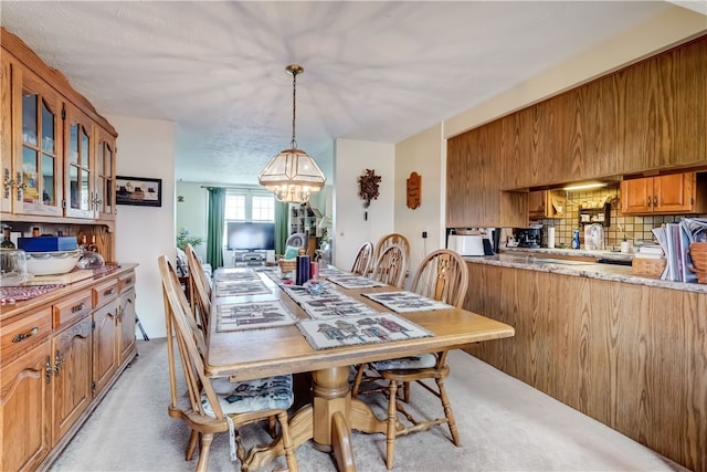 dining room featuring light carpet and an inviting chandelier