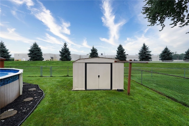 view of outbuilding with a rural view, a fenced in pool, and a yard