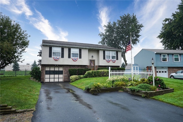 bi-level home featuring a garage and a front lawn