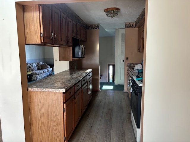 kitchen featuring white electric range, dark hardwood / wood-style flooring, and a textured ceiling