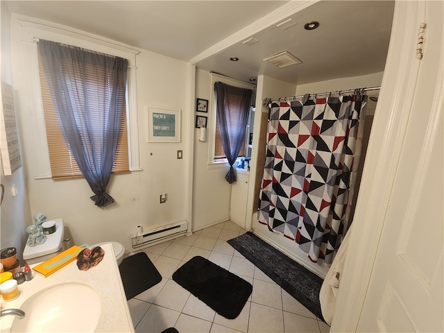 bathroom featuring baseboard heating, a wealth of natural light, tile patterned floors, and sink