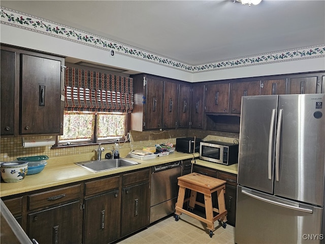 kitchen featuring backsplash, stainless steel appliances, dark brown cabinetry, and sink