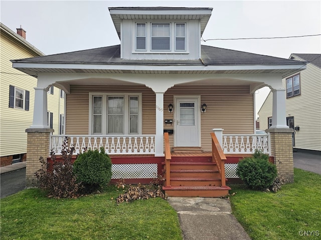 view of front of property featuring covered porch and a front yard