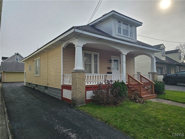 view of front of property with covered porch and a front yard