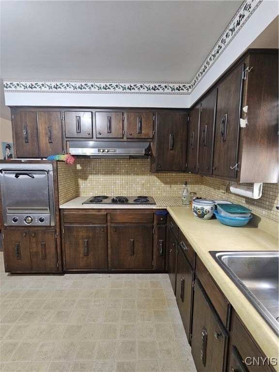 kitchen featuring dark brown cabinets, decorative backsplash, and gas cooktop