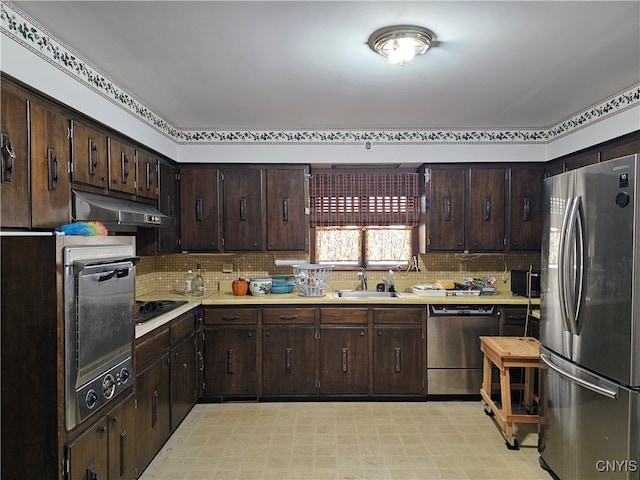 kitchen with backsplash, dark brown cabinetry, sink, and appliances with stainless steel finishes