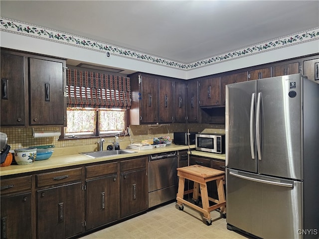 kitchen featuring backsplash, sink, stainless steel appliances, and dark brown cabinets