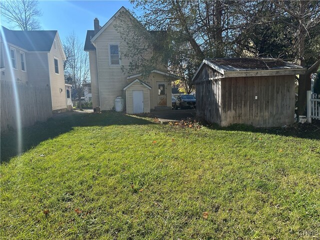 rear view of property with a shed and a yard