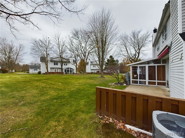 view of yard featuring a sunroom and central AC unit