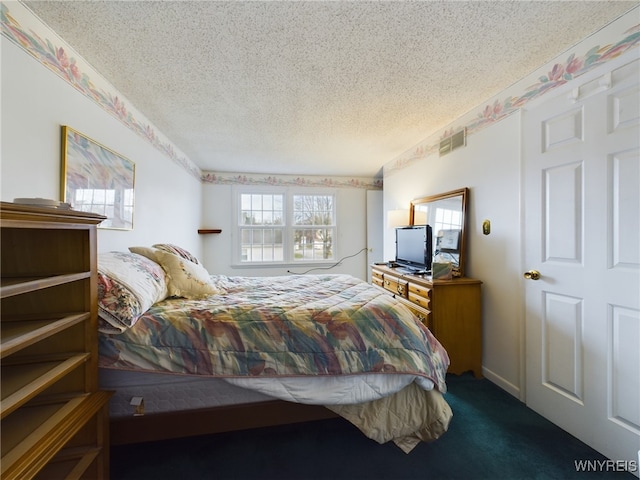 bedroom with dark carpet and a textured ceiling