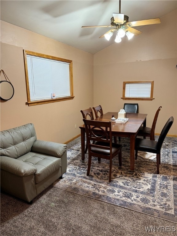 dining space with carpet flooring, ceiling fan, and lofted ceiling