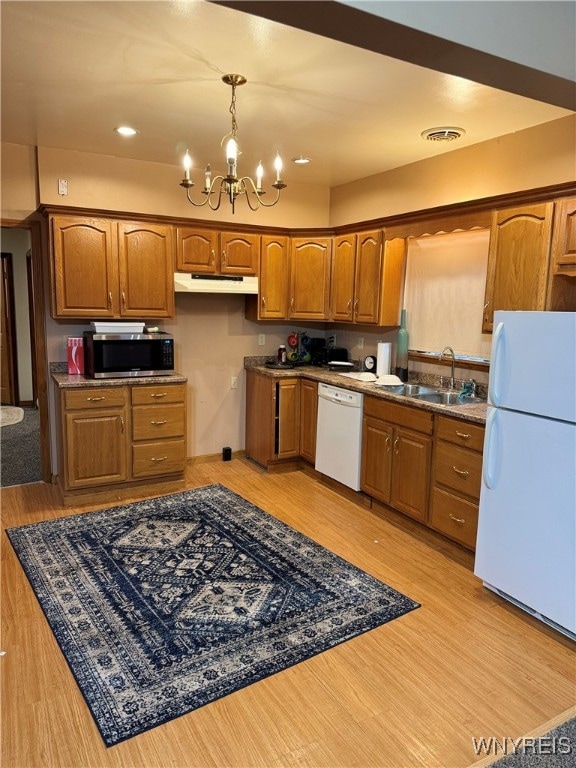 kitchen with white appliances, light hardwood / wood-style flooring, a notable chandelier, and sink