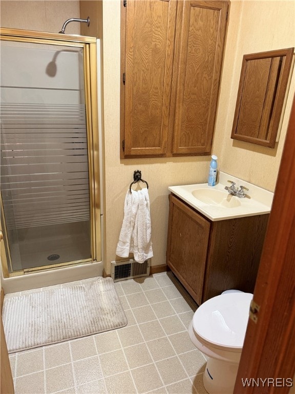 bathroom featuring vanity, toilet, and a shower with door