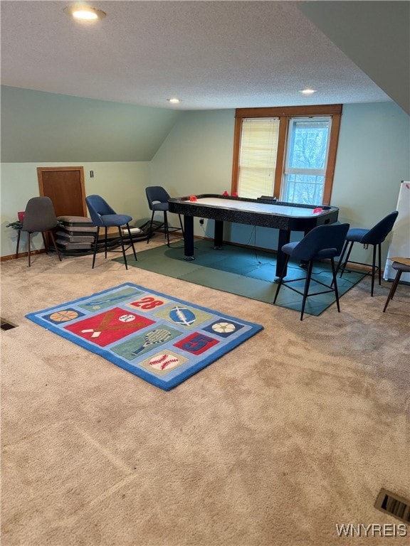 playroom with carpet flooring, a textured ceiling, and vaulted ceiling