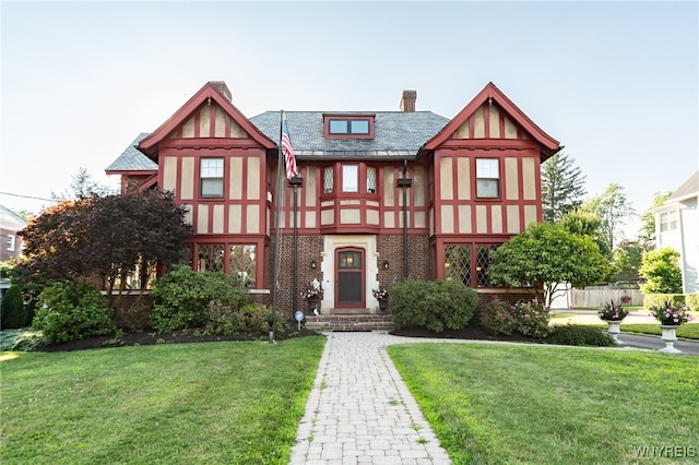 english style home featuring a front yard