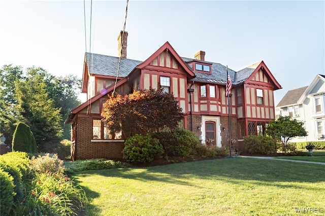 tudor-style house featuring a front yard