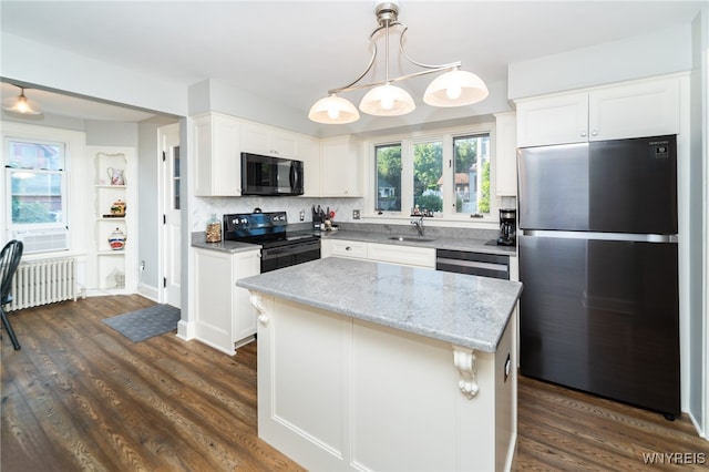 kitchen with radiator, white cabinets, dark hardwood / wood-style floors, a kitchen island, and stainless steel appliances