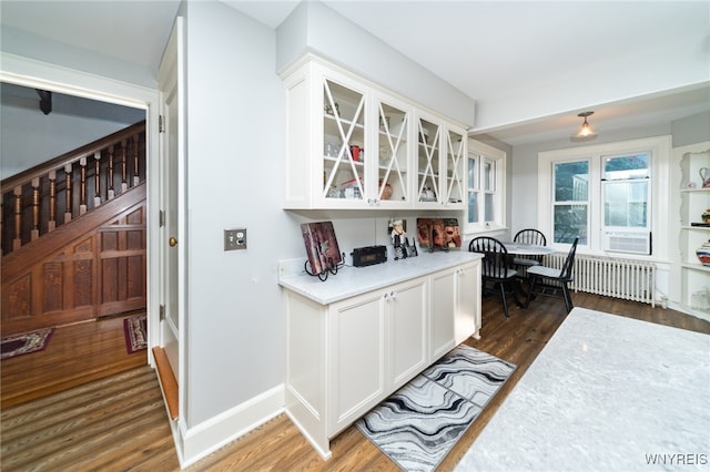 interior space with white cabinetry, radiator heating unit, cooling unit, and dark hardwood / wood-style floors