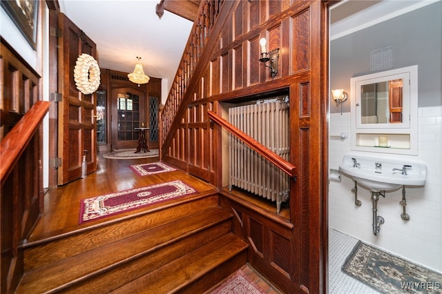 staircase featuring hardwood / wood-style flooring and sink