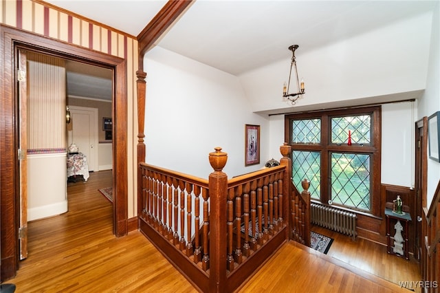 interior space featuring radiator heating unit, vaulted ceiling, a notable chandelier, and hardwood / wood-style floors