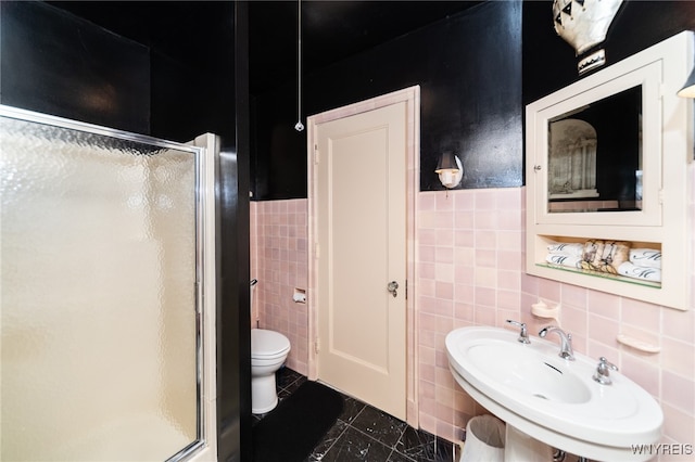 bathroom featuring an enclosed shower, toilet, tile walls, and sink