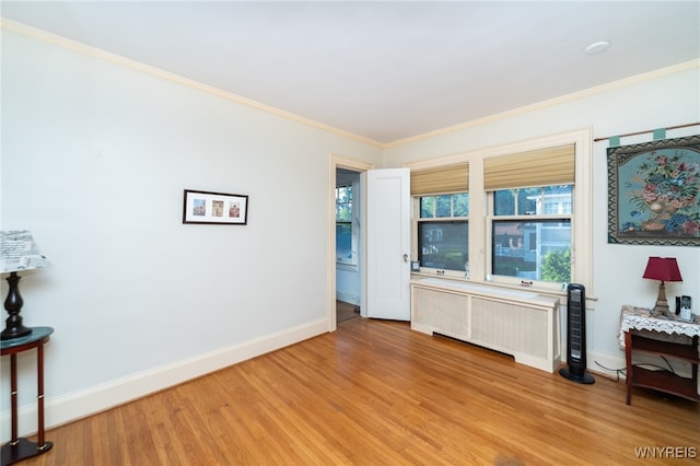 interior space with light hardwood / wood-style floors, radiator, and crown molding