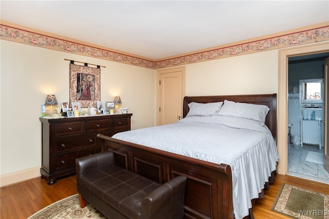 bedroom with wood-type flooring and radiator