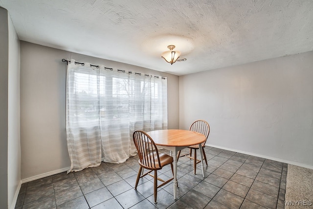 tiled dining area with a textured ceiling