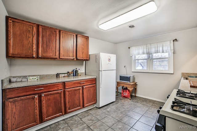 kitchen featuring white appliances and light tile patterned floors