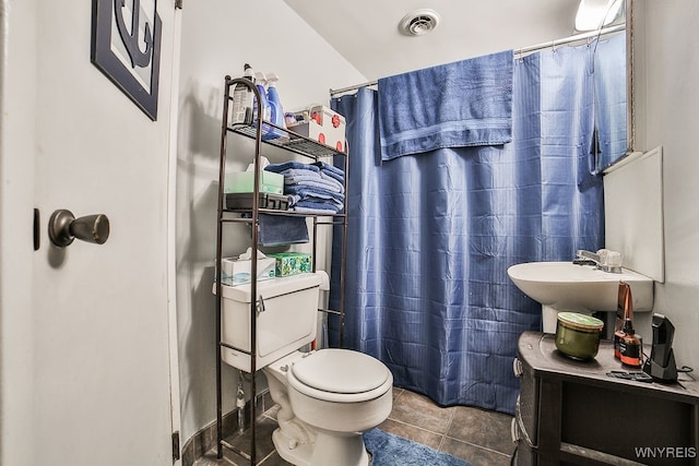 bathroom featuring tile patterned flooring, toilet, and sink