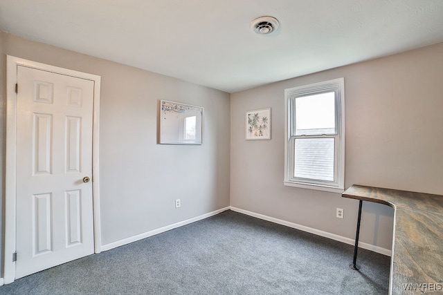 unfurnished room featuring dark carpet