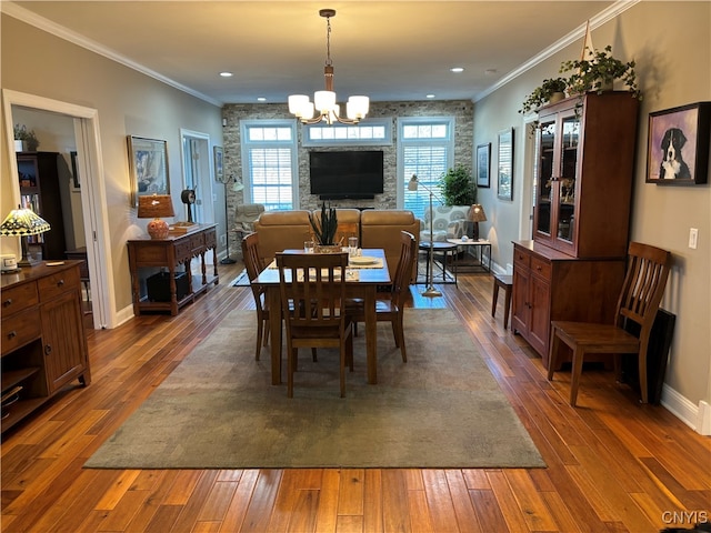 dining room with dark hardwood / wood-style floors, crown molding, and a notable chandelier