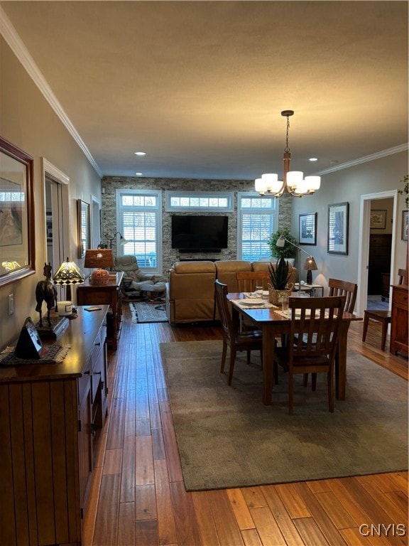 dining area with crown molding, dark hardwood / wood-style floors, and a notable chandelier