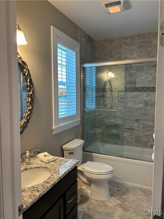 full bathroom with vanity, toilet, and shower / bath combination with glass door