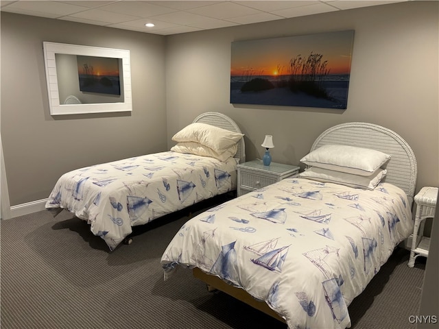 carpeted bedroom featuring a drop ceiling