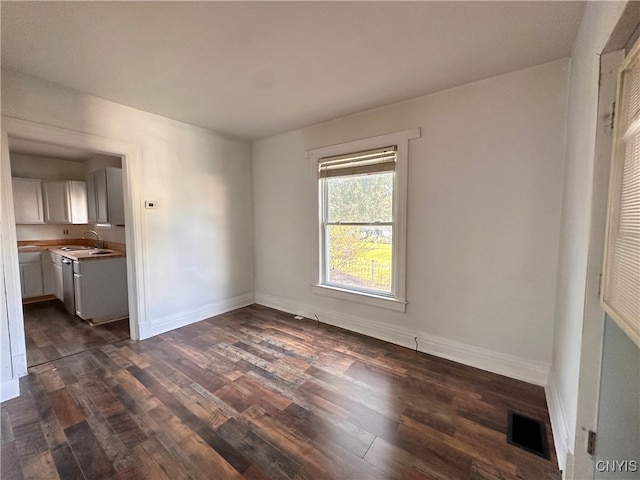 spare room with dark hardwood / wood-style flooring and sink