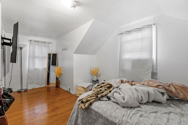 bedroom featuring hardwood / wood-style floors and lofted ceiling