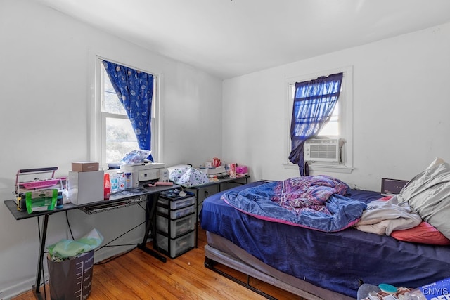 bedroom with cooling unit and hardwood / wood-style flooring