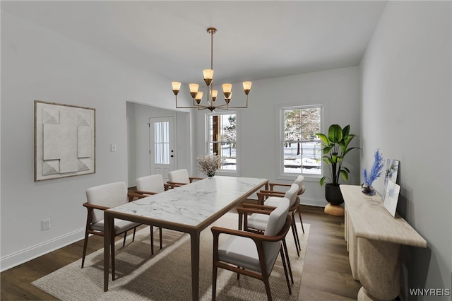 dining room featuring dark hardwood / wood-style flooring and an inviting chandelier