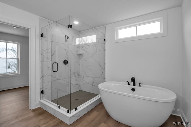 bathroom featuring separate shower and tub and wood-type flooring