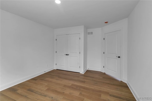 unfurnished bedroom with a closet and wood-type flooring