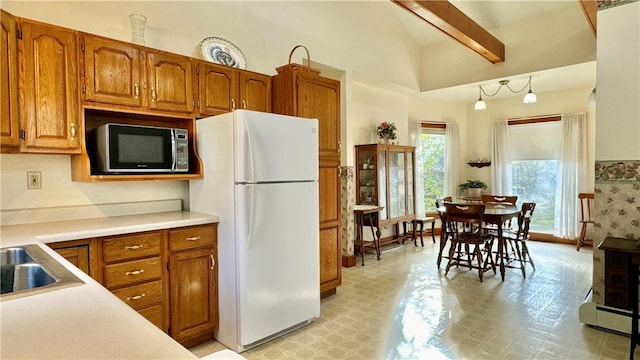 7603 State Highway 7, Maryland, NY 12116 - kitchen featuring freestanding refrigerator, stainless steel microwave, brown cabinets, light countertops, and high vaulted ceiling