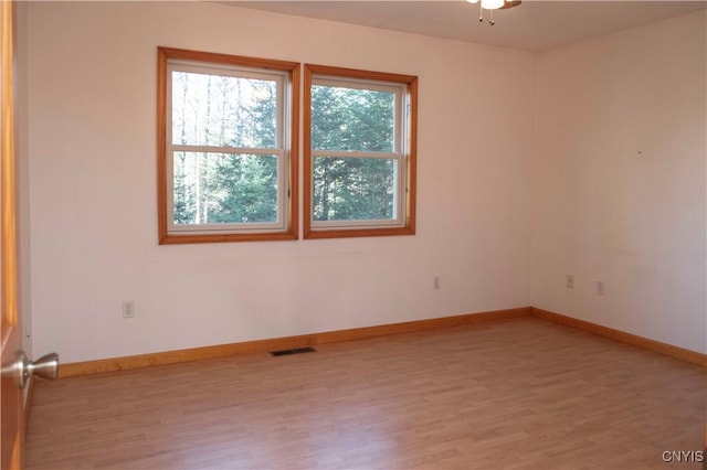 spare room with ceiling fan and light wood-type flooring